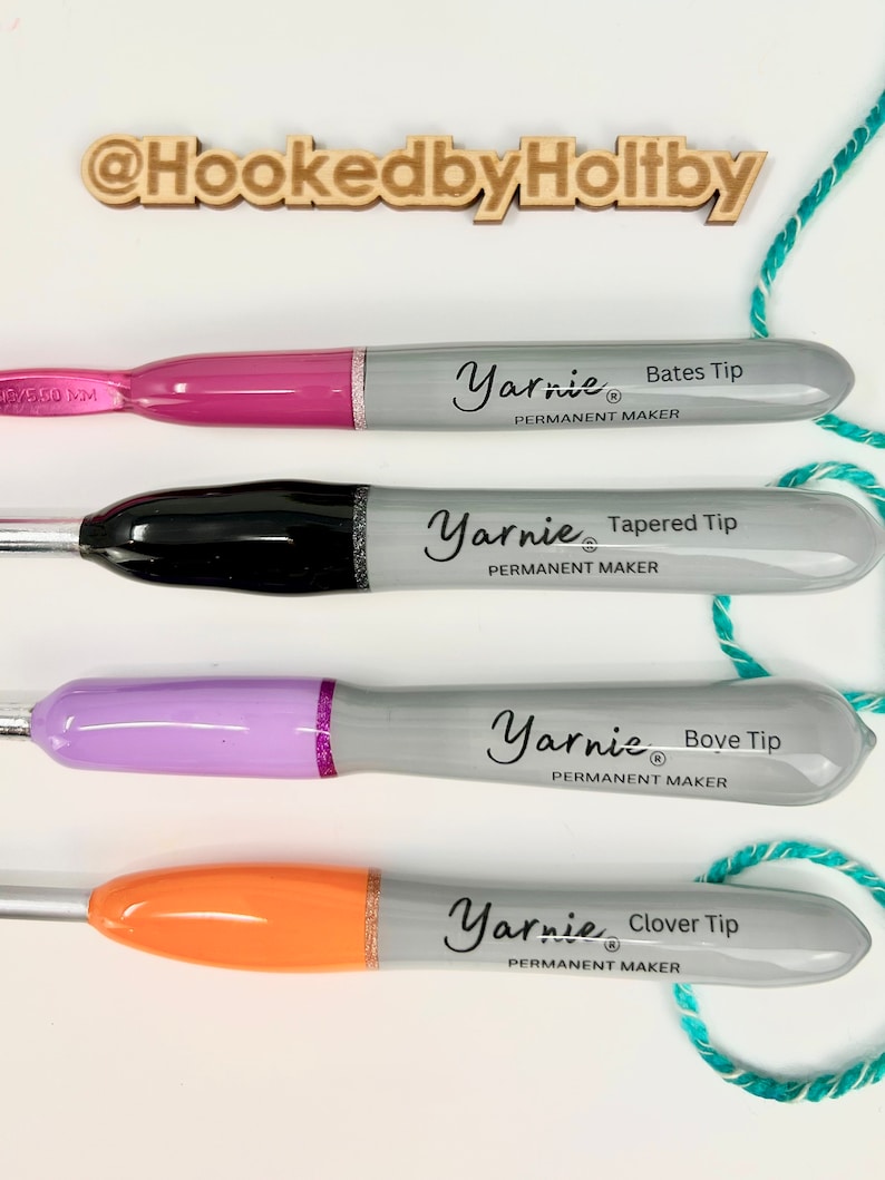 Pu&ograve; includere: Quattro pennarelli permanenti con punte di colore diverso e il testo "Yarnie&reg; Permanent Maker" sul lato. Le punte sono etichettate "Bates Tip", "Tapered Tip", "Bove Tip" e "Clover Tip".