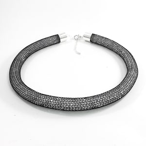 hand made wire crochet bluish black tube necklace, filled with harmonising rock crystal chips
