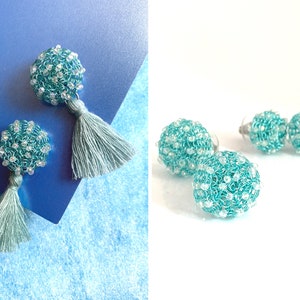 May include: A pair of turquoise blue beaded earrings with a tassel on one side. The earrings are shown on a blue background and a white background.