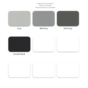 May include: A grid of eight rectangular color swatches featuring various shades of gray and black, including labeled options for Gray, Mid Gray, Dark Gray, and Smooth Black, alongside several blank white rectangular swatches in a grid layout.