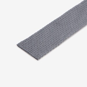 May include: A close-up of a grey woven cotton webbing strap.