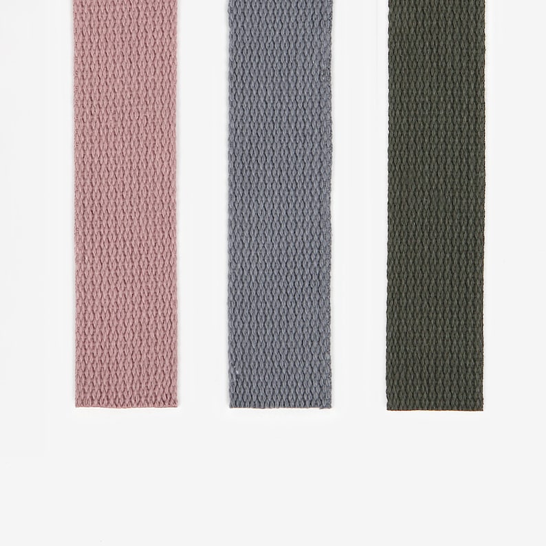 May include: Three fabric straps in pink, grey, and green. The straps are woven with a textured pattern.