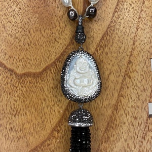 Mother of Pearl Bhudda Hand Carved  Pendant 1 1/8  inches tall with Jet stone tassel. Fresh water pearl long necklace 40 inches long