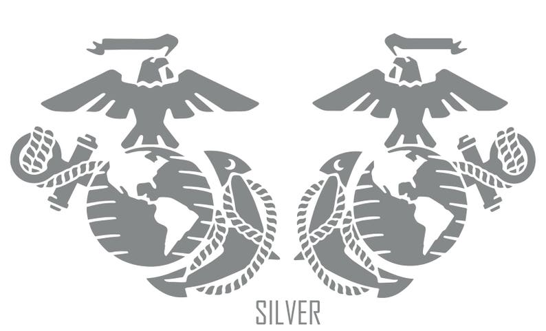 May include: A silver-coloured, stylised image of the United States Marine Corps emblem. The emblem features a globe, an eagle, and an anchor. The text "SILVER" is printed below the emblem.