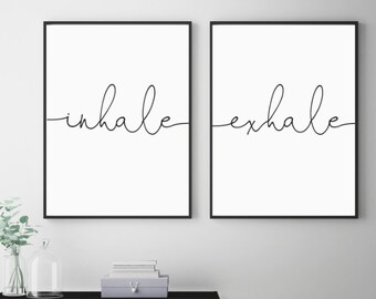 Puede incluir: Dos láminas de arte mural rectangulares en marcos negros finos. La lámina de la izquierda muestra la palabra inhale en letra cursiva negra sobre fondo blanco. La lámina de la derecha muestra la palabra exhale en letra cursiva negra sobre fondo blanco.
