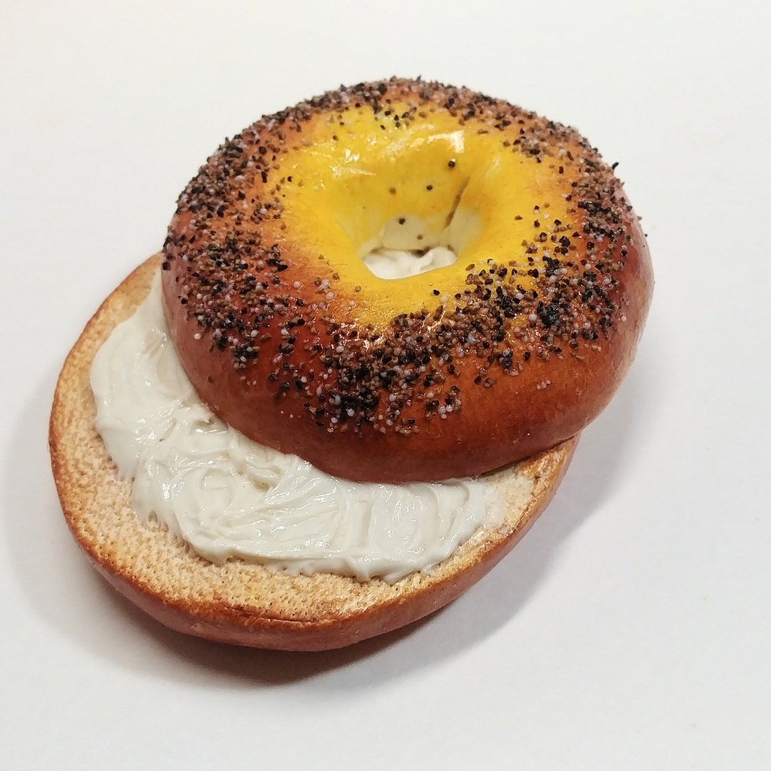 Delicioso bagel con queso crema sobre un fondo blanco | Foto Premium