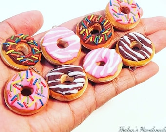 May include: A collection of eight miniature donut charms, each with a different glaze and sprinkles. The donuts are made of polymer clay and are approximately 1 inch in diameter. The charms are perfect for adding a touch of whimsy to jewelry, keychains, or bags.
