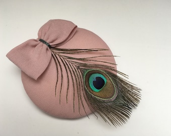 Puderrosa Fascinator mit Schleife und Pfauenfeder