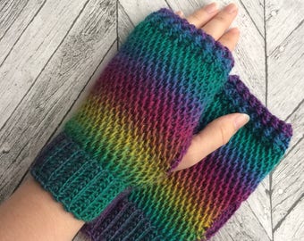 May include: A pair of rainbow colored fingerless gloves knitted in a textured stitch.