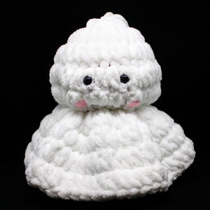 May include: White crocheted ghost with black eyes and pink cheeks. The ghost is made of a soft, fluffy yarn.