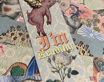 May include: A blue and gold bookmark with a pink pig with gold wings flying, a white rose, and the text "I'm Reading".
