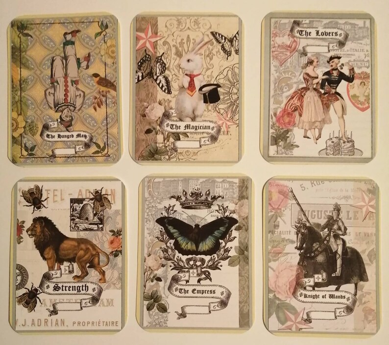 May include: Six vintage tarot cards with ornate designs and illustrations. The cards feature images of a hanged man, a magician with a rabbit, lovers, a lion, an empress with a butterfly, and a knight on a horse.