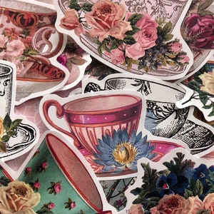 Könnte beinhalten: Sortiment von Vintage-Teetassen-Aufklebern mit Blumendesigns. Die Aufkleber zeigen rosa, blaue und grüne Blumen mit filigranen Details.