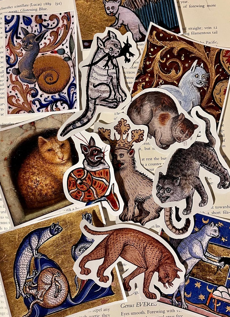 May include: A collection of vintage cat illustrations printed on stickers. The stickers feature cats in various poses, including a cat wearing a crown, a cat curled up in a shell, and a cat with a long tail. The stickers are printed on white paper with a slightly textured surface.