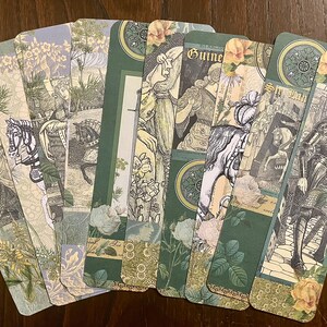 May include: A set of ten green and cream bookmarks with a vintage aesthetic. Each bookmark features a different illustration of a knight, a horse, or a floral design. The bookmarks are decorated with gold accents and have a scalloped edge.