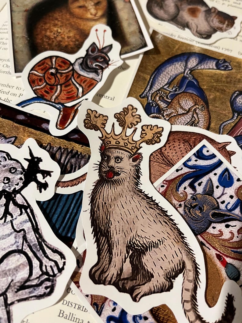 May include: A collection of vintage cat illustrations printed on stickers. The stickers feature a variety of cats in different poses, including a cat wearing a crown, a cat curled up in a snail shell, and a cat sitting on a throne. The stickers are printed on white paper with a black outline.