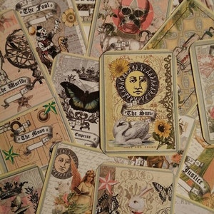 May include: A collection of tarot cards with various illustrations, including a swan, a butterfly, a sun, a moon, and a skull. The cards are decorated with floral patterns and have a vintage aesthetic.