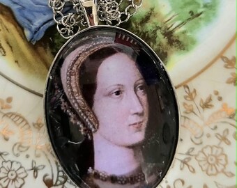 May include: An oval silver-toned pendant necklace featuring a portrait of a person wearing a beaded headpiece and a necklace. The pendant is attached to a silver-toned link chain, showcasing a detailed historical-style image under a glass dome.