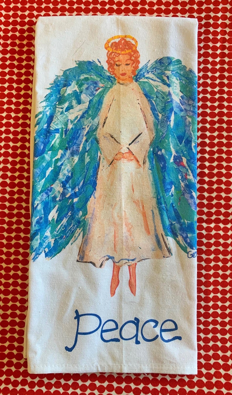 May include: White kitchen towel with a blue and green watercolor angel with a halo and the word "Peace" printed below.