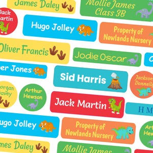 May include: A selection of brightly coloured name labels, each featuring a child's name and a dinosaur illustration. The labels are rectangular and circular, with names such as "Hugo Jolley" and "Jack Martin". Some labels also include the text "Property of Newlands Nursery".