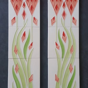 May include: Two rectangular ceramic tiles with a floral design. The design features stylized red diamond-shaped flowers and green leaves on a white background. The tiles are arranged vertically, side by side.
