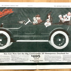 May include: An advert from The Saturday Evening Post shows an Overland car with passengers. The car is dark green with white wheels. The text reads "You Can Now Get the Big, Comfortable 35 Horsepower Overland for £695."
