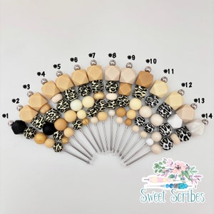 以下が含まれることがあります： ヒョウ柄のデザインが施された木製とシリコンビーズの串が14本セットになっています。串は扇形に配置されており、各串の裏側に1から14までの番号が印刷されています。