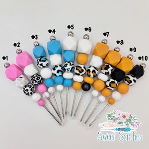 以下が含まれることがあります： ヒョウ柄、白、黒、青など、さまざまなパターンが施された、カラフルなシリコンビーズ串が10本あります。串は1から10まで番号が付けられています。