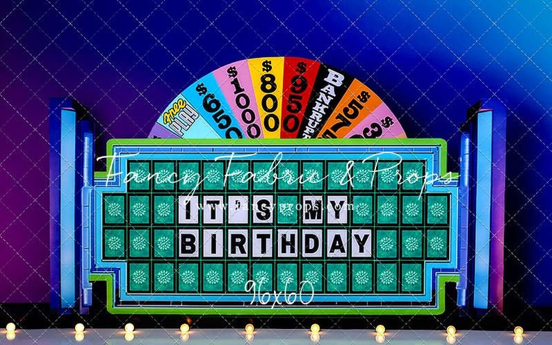 May include: A green and blue game board with the phrase "IT'S MY BIRTHDAY" on it. The board is surrounded by a colorful wheel with dollar amounts and the word "BANKRUPT".