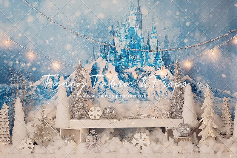 Pu&ograve; includere: Uno sfondo invernale con un castello blu, montagne innevate bianche e uno scaffale in legno bianco con decorazioni argentate e bianche. Il testo "Fancy Fabric & Props www.fancyprops.com" &egrave; visibile nell'immagine.