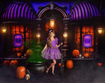 May include: A young person in a purple dress and witch hat stands in front of a Magic Shop. The shop has purple and black striped awnings, orange windows, and glowing lanterns. A cauldron with green smoke, pumpkins, and a broom complete the Halloween scene.