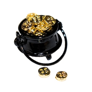 May include: A black cauldron filled with gold coins, with two additional coins spilling out onto a white surface.