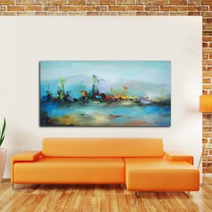 May include: Abstract landscape painting in blue, teal, and yellow. The artwork shows a waterfront scene with buildings and reflections. The painting is displayed above an orange sofa in a modern living room setting.