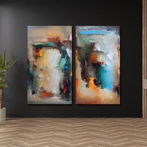 Könnte beinhalten: Zwei abstrakte Gemälde mit einem strukturierten, farbenfrohen Design. Das Kunstwerk zeigt eine Mischung aus Farben, darunter Orange, Blau und Grün, vor einem neutralen Hintergrund. Die Gemälde werden an einer dunklen Wand in einem Raum mit Holzboden ausgestellt.
