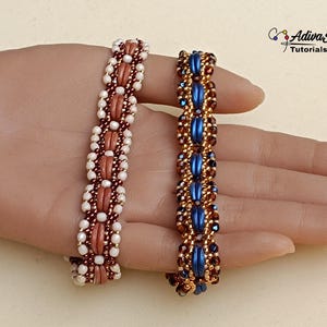 Puede incluir: Dos pulseras de cuentas. Una es principalmente coral con detalles blancos y marrones. La otra es azul, dorada y marrón. Las pulseras se muestran en una mano. Probablemente sean joyas hechas a mano.