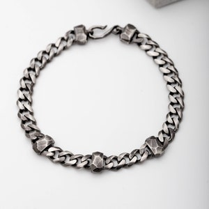 Thick Cuban link chain bracelet with three hand carved elements on the chain. A great gift for him.