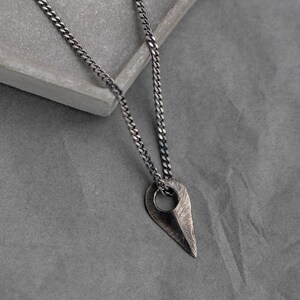 Men's and women's sterling silver arrow necklace with a brutalist aesthetic, entirely handmade and finished with oxidized silver.