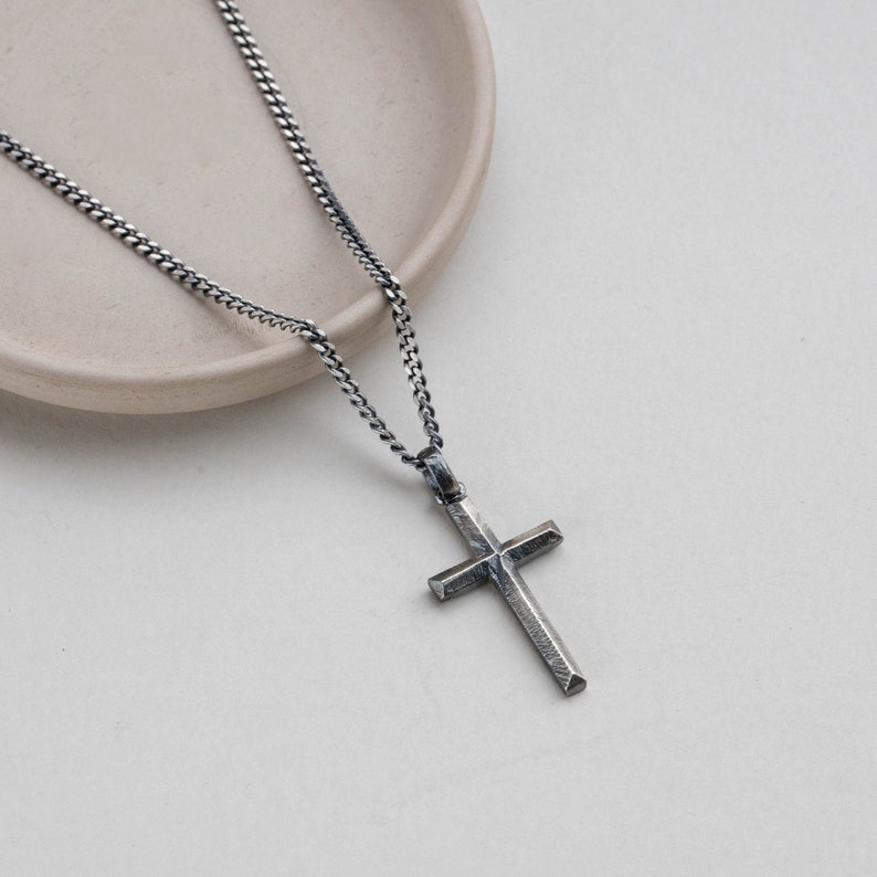 Brutalist cross pendant, totally handmade, hanging on a curb chain. the necklace is made of oxidized silver 925.