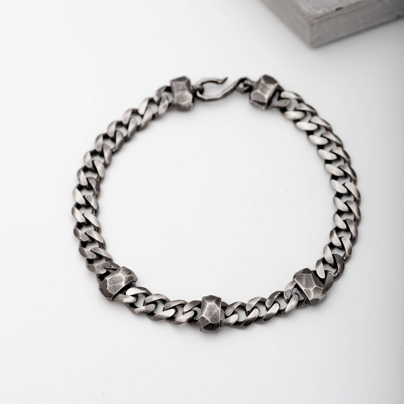 Thick Cuban link chain bracelet with three hand carved elements on the chain. A great gift for him.