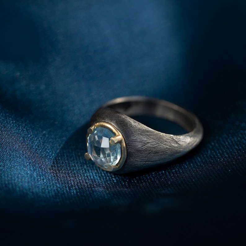 Dome gemstone ring for men and women in oxidized sterling silver with solid gold details and a natural blue topaz gemstone.