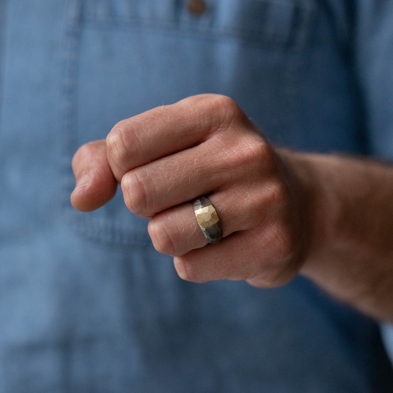 Wide gradient band ring on a male model's ring finger. The ring is made of oxidized sterling silver and 14K gold.