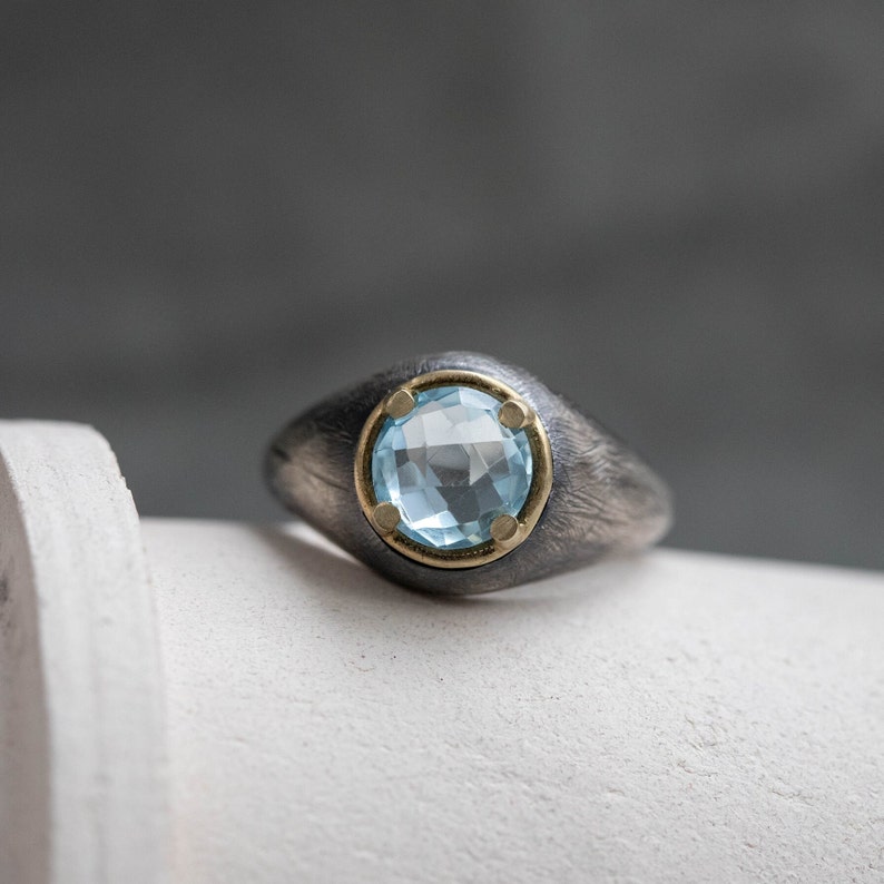 Blue topaz ring in oxidized silver with 14K solid gold details. The stone is 8mm diameter and the ring is perfect for men and women.