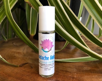 May include: A white roll-on bottle with a pink and blue flower design and the text "Nature's Love Shop Mind Body Soul Headache Help Essential Oil Blend Peppermint, Eucalyptus, Lavender Organic Fractionated Coconut Oil Apply to temples and around your neck."