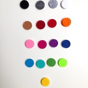 May include: Assortment of felt circles in various colours, including black, grey, white, brown, red, orange, pink, purple, blue, green, yellow, and lime green.