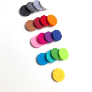 May include: A set of 14 round felt diffusers in various colours, including grey, white, brown, red, orange, pink, purple, blue, green, and yellow. The diffusers are arranged in a staggered pattern on a white background.