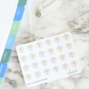 May include: A sheet of white stickers with a gold cross and the words "Eternal Rest" in blue lettering. The stickers are arranged in a grid pattern and are labeled "death anniversary reminder".