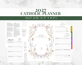 May include: A 2027 Catholic planner measuring 5.5 inches by 8.5 inches. The cover features a central floral wreath design with the text 2027 Simply Catholic Planner. Interior pages show a March calendar layout and daily scheduling sections.