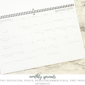 May include: A white, spiral-bound calendar open to December 2026. The calendar features a grid layout with dates and space for notes. The text "monthly spreads" and a list of events are at the bottom.