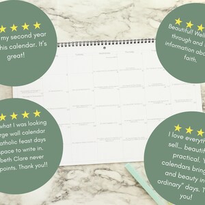 May include: A white wall calendar with a spiral binding, open to a blank month view. The calendar is on a marble surface, with green circles containing customer reviews and gold stars. A light green pen rests nearby.