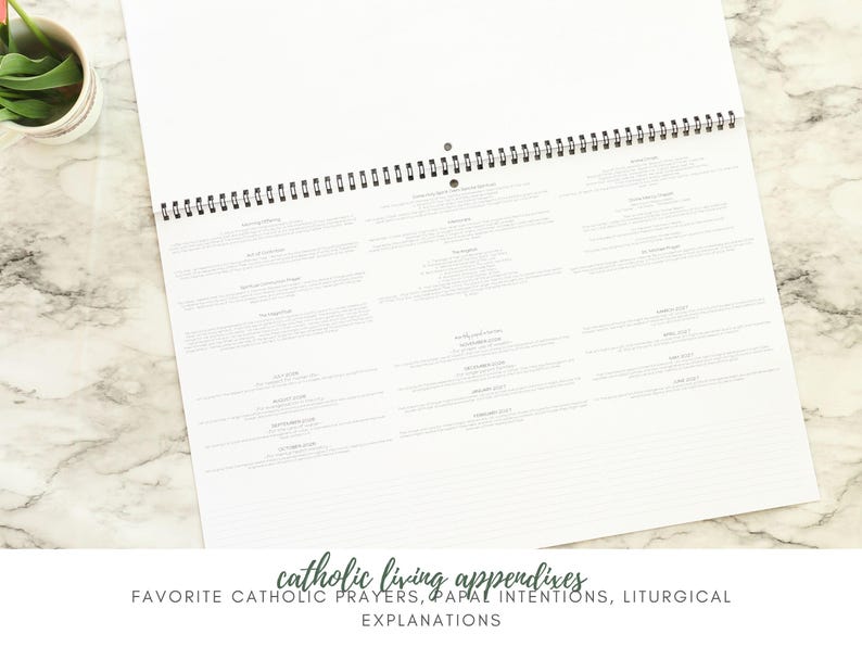 May include: A white spiral-bound calendar open to a page with text. The text is organized into rectangular blocks. The bottom of the image has the text "catholic living appendixes" and "favorite catholic prayers, papal intentions, liturgical explanations."